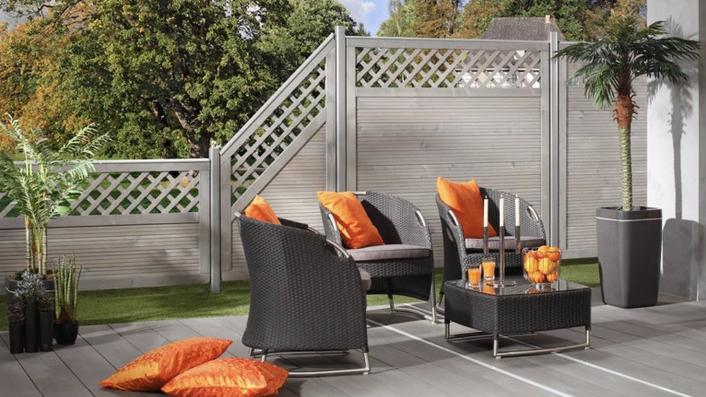 eine Terrasse mit einem modernen Sichtschutzzaun